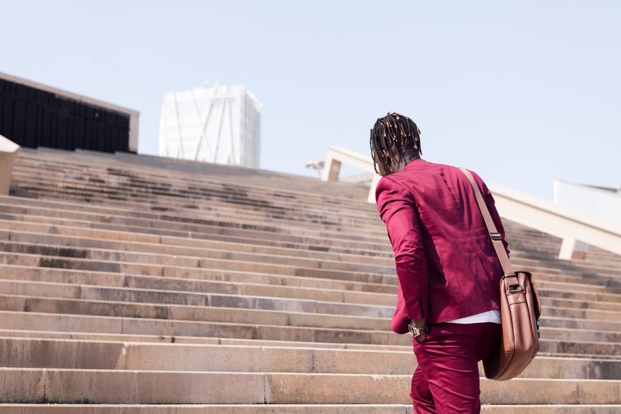 Businessman ascending outdoor city stairs.