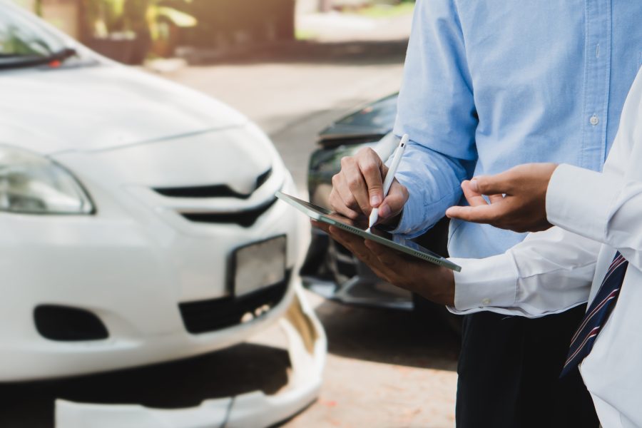 Two men discussing car insurance details.