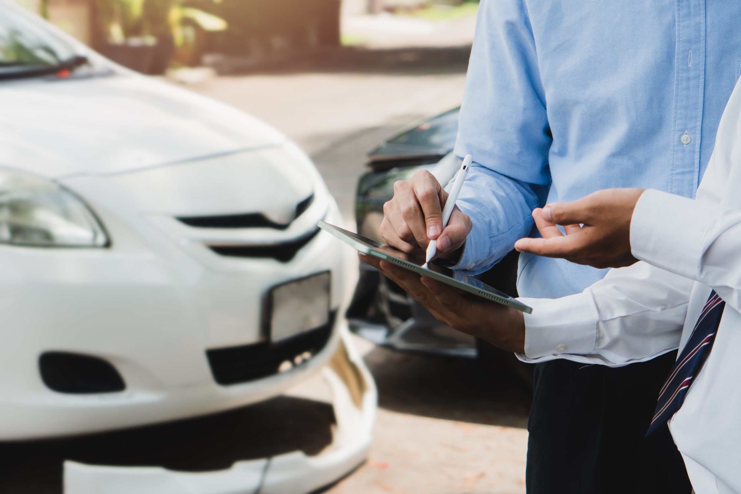Two men discussing car insurance details.