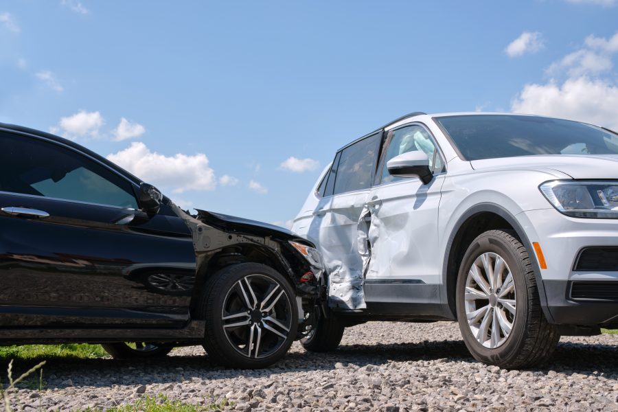 Damaged in heavy car accident vehicles after collision on city street crash site. Road safety and insurance concept.