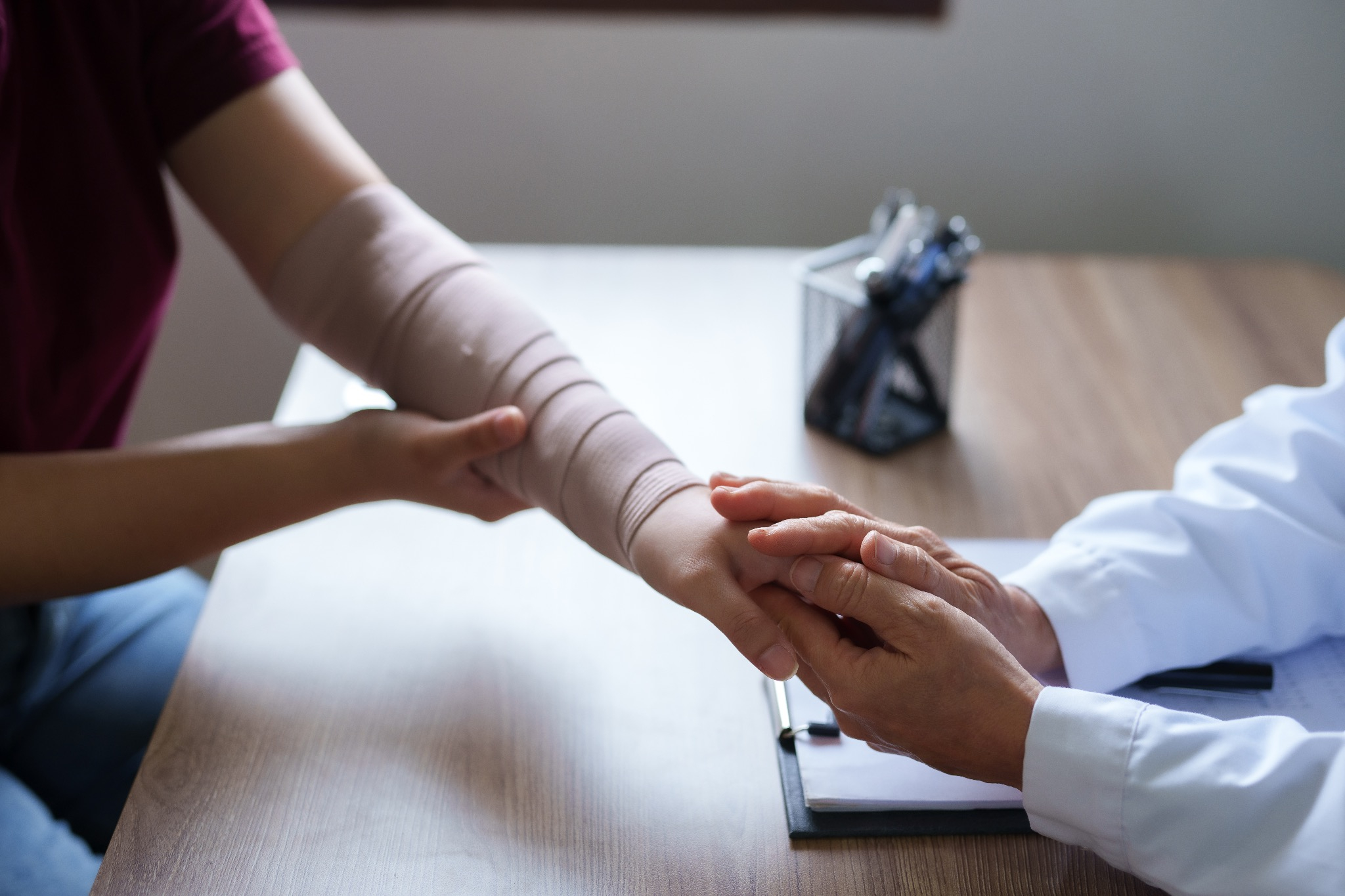 Doctor is examining the arm of a female patient who has been in an accident.