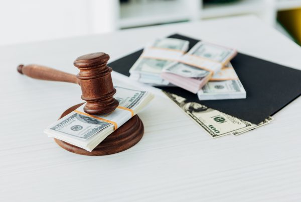 selective focus of gavel of judge near dollar banknotes on table